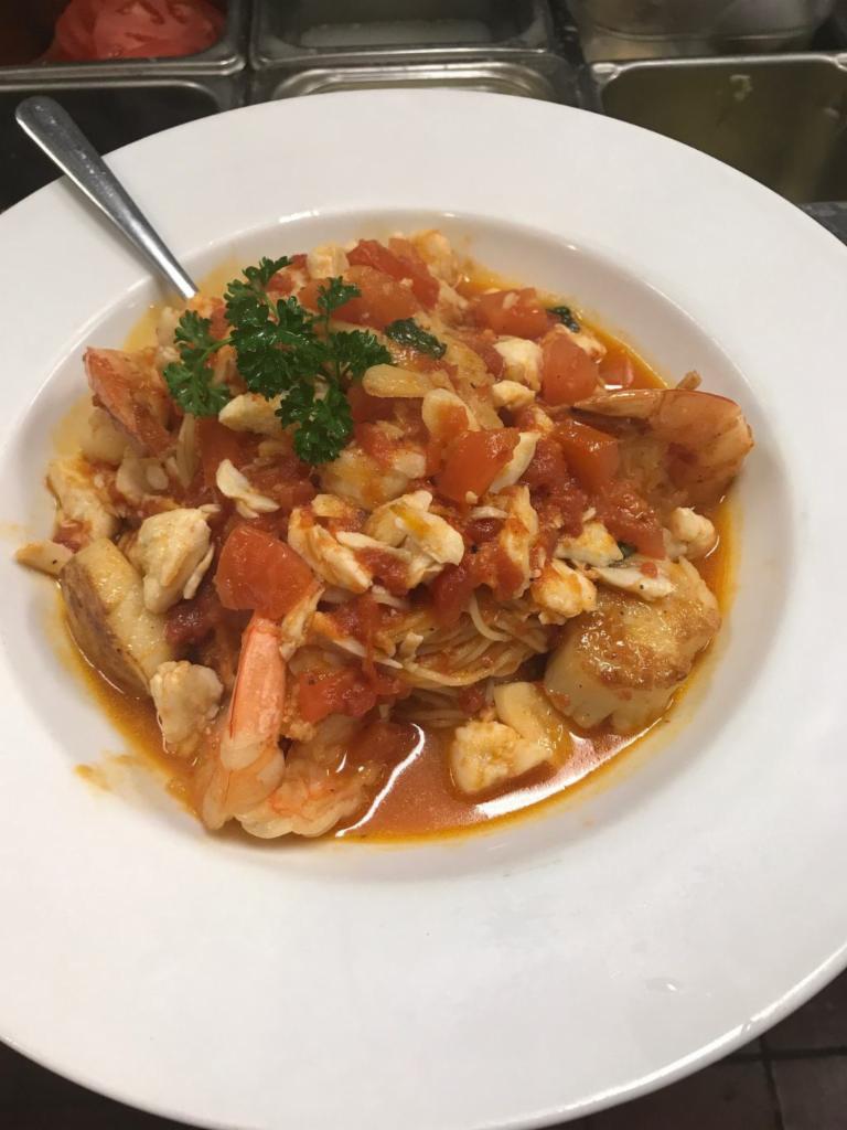 Seafood Ninfea · Jumbo lump crab meat, scallops and jumbo shrimp sauteed in a white wine garlic sauce with fresh tomatoes and a touch of marinara, served over capellini. Served with choice of salad or soup.