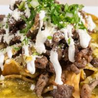 Stake Chilaquiles · A handful of fried tortilla chips topped with powered cotija cheese, melted Monterey Jack ch...