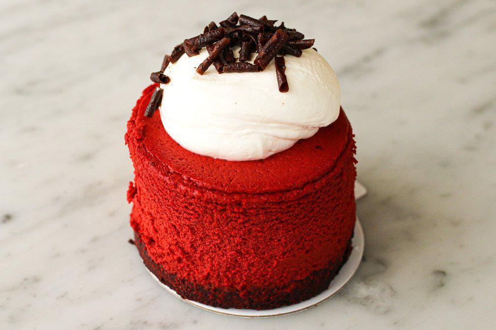 Red Velvet Cheesecake to go · Our popular red velvet cheesecake sits atop a chocolate cookie crumb crust, topped with fresh whipped cream and chocolate shavings.