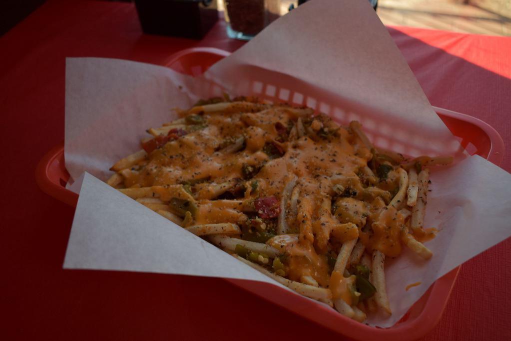 Green Chile Cheese Fries · Our Garlic Parm Fries topped with Green Chile and Cheddar Cheese Sauce