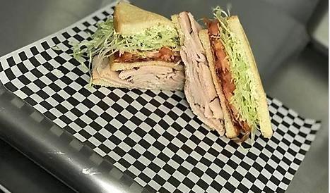 Turkey Club Sandwich · Pan-roasted turkey, bacon, lettuce, tomato, and mayo layered between 3 pieces of toasted white bread.