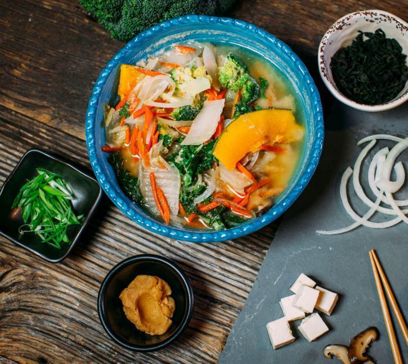 Earthy Miso Soup Bowl · Shiitake, tofu, napa, carrot, onion, wakame, kabocha, greens, broccoli, ginger and scallions in gluten-free miso.