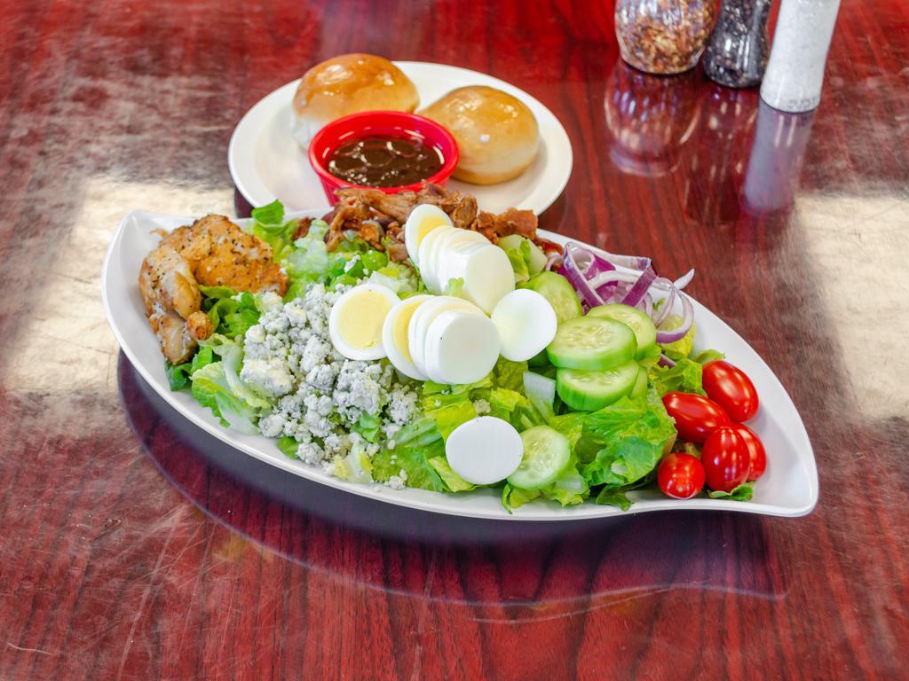 Cobb Salad · Romaine lettuce, blue cheese crumbles, hard-boiled egg, avocado, tomatoes, cucumber, purple onion, bacon, and chicken.