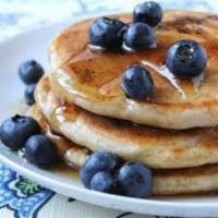 Blueberry Pancakes · 3 fluffy blueberry pancakes with maple syrup and butter.