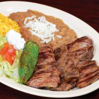 Carne Asada · Skirt steak, grilled onion, salad and avocado. Served with Rice and Beans