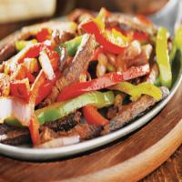 Steak Fajitas · Grilled Skirt steak mixed with grilled veggies. Served with Rice and Beans