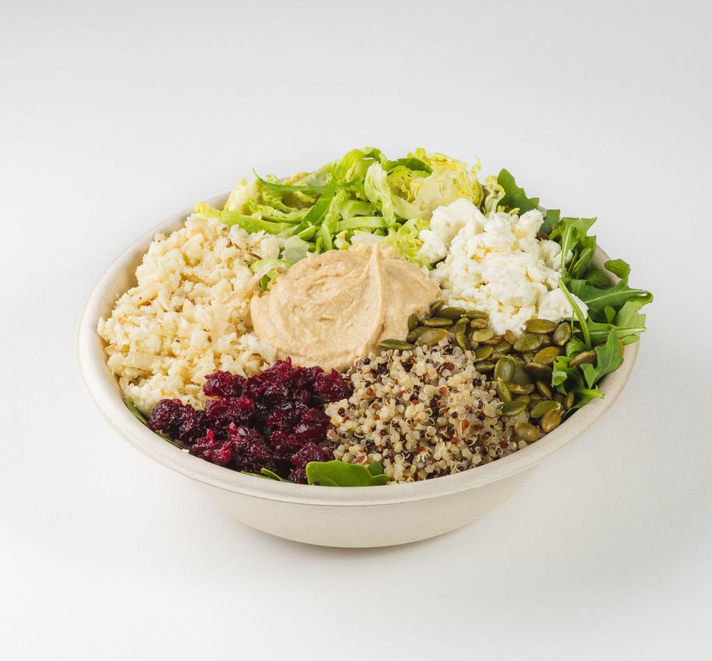 Riced Cauliflower and Artichoke Hummus Grain Bowl · Cauliflower rice, tri-color quinoa, artichoke hummus, feta, arugula, roasted Brussels sprouts, cranberry beet relish and toasted pumpkin seeds with pomegranate vinaigrette. Vegetarian. Gluten-free.
