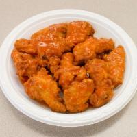Buffalo Wings · Wings with Buffalo sauce in a small bowl.