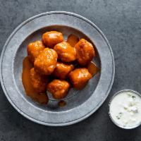 Buffalo Popcorn Chickin · Crispy popcorn Chickin’ tossed in buffalo sauce served with a housed-made blue cheese dressing