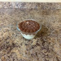 Tiramisu Glass · Sponge cake soaked in espresso, topped with mascarpone cream and dusted with cocoa powder.