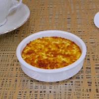 Creme Brulee-In Ramekin · A creamy custard presented in a traditional ceramic ramekin and comes with a packet of sugar.