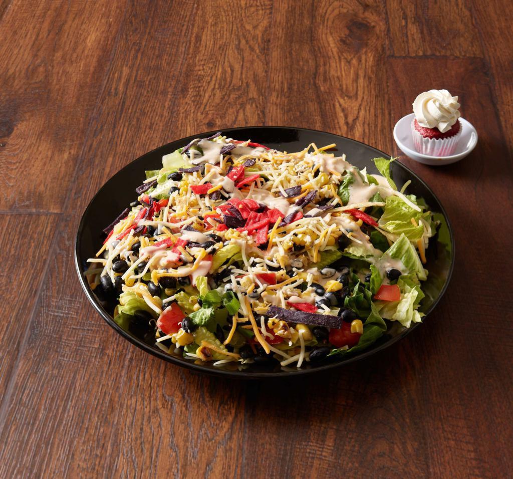 Southwest BBQ Chicken Salad · Crisp romaine lettuce, roasted BBQ chicken breast, Colby Jack cheese, Roma tomatoes, green onion, black beans, roasted sweet corn, topped with tortilla strips, and served with creamy BBQ ranch dressing.