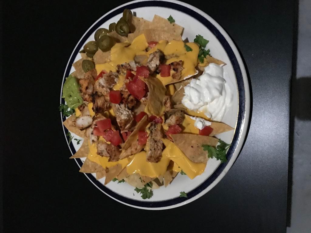Nachos · Fresh tortilla chips, topped with nacho cheese, salsa, guacamole, sour cream and jalapeno.