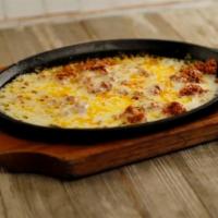 Queso Fundido · Monterrey Jack cheese melted to perfection topped with pork chorizo. Served with warm tortil...
