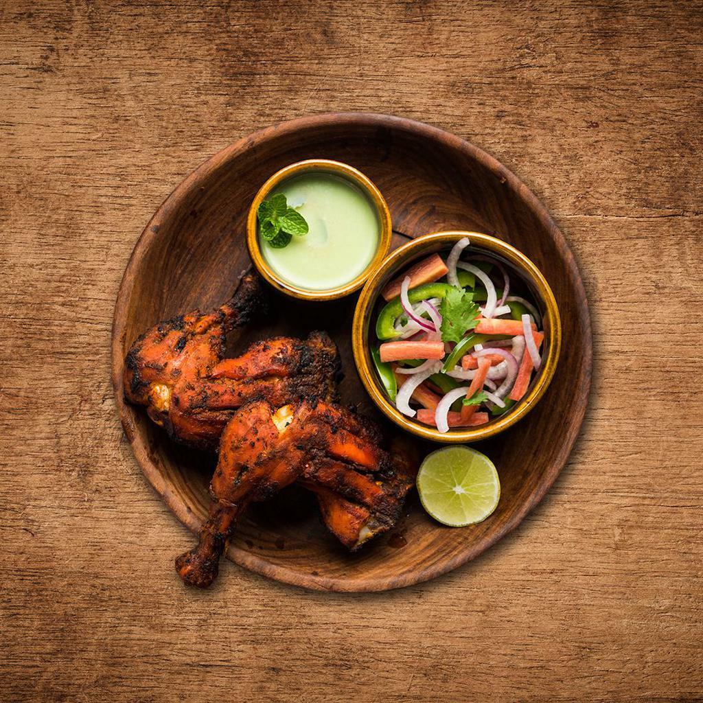 Charred Tandoori Chicken · Chicken marinated overnight in a prepared mix of yogurt, spices, herbs, and cooked in a clay oven.
