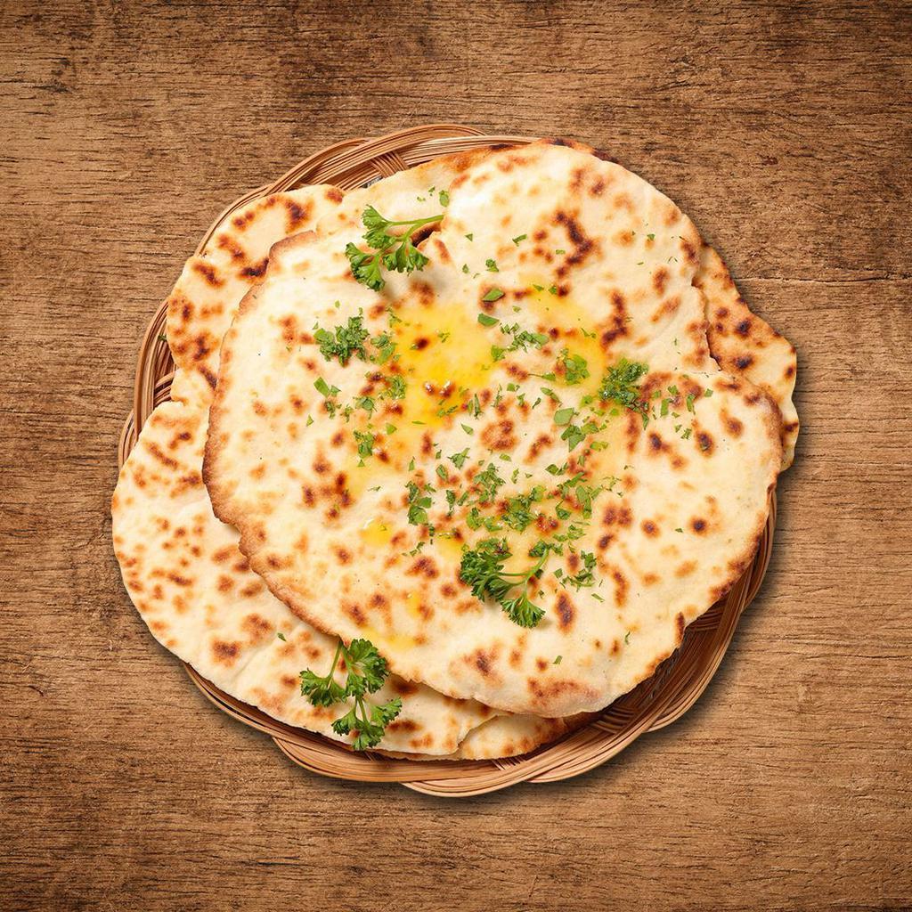 Butter Naan · House made hand pulled and leavened dough baked to perfection in an Indian clay oven and basted with generous amounts of butter 
