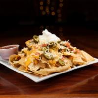Loaded Nachos · A mountain of beef, beans, onions, tomatoes, sour cream, jalapenos and cheese.