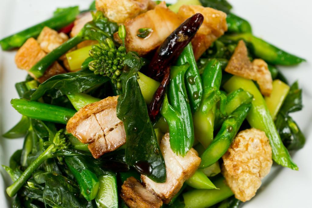 Kana Fai Dang · Chinese broccoli woked in garlic and soy bean past.  Adding salty fish or crispy pork is recommended.  (Picture shown with crispy pork)