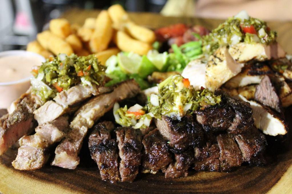 The Aqua Meat Platter · Dominican sausage longaniza, grilled steak, grilled chicken, grilled pork chops, yuca fries and chimichurri sauce.