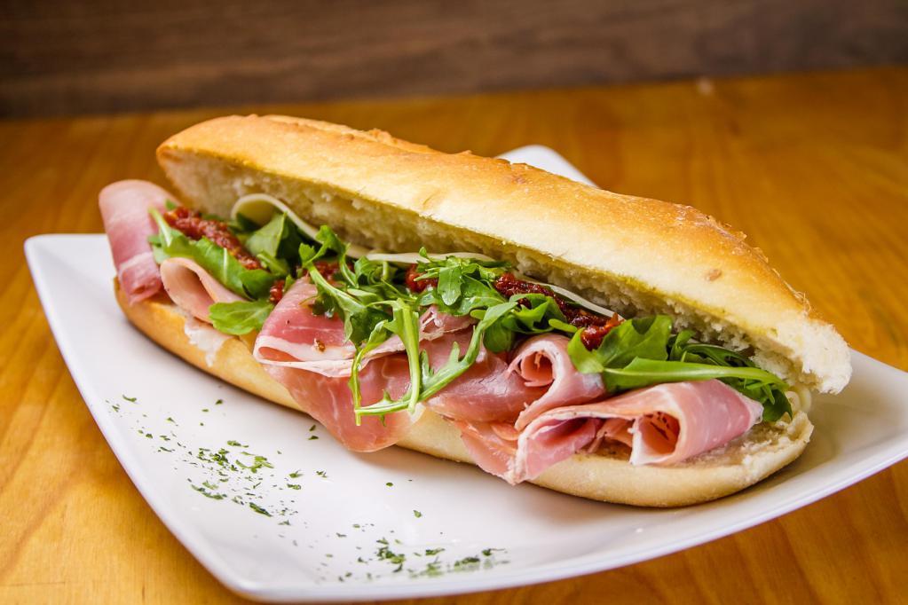 Prosciutto Sandwich · Prosciutto, confit tomatoes, basil pesto, provolone cheese, arugula, extra virgin oil and balsamic vinegar.