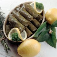 Stuffed Grape Leaves · Vine grape leaves stuffed with rice and a blend of Mediterranean herbs and spices atop a bed...