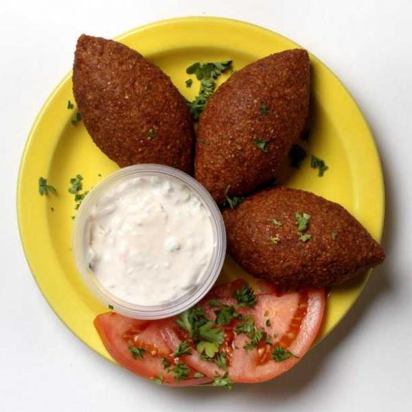 Kibbie Bowl · A bed of our homemade Greek Rice or Mujadara (Lentil and Rice), topped with kibbie, feta cheese, onion, diced tomatoes, cucumber, lettuce, banana peppers, served with our house Greek dressing and a side of pita bread. 