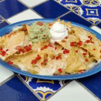 Nachos el Deluxe · Melted cheese over refried beans, chips, mild red, and green chilies. Served with guacamole ...