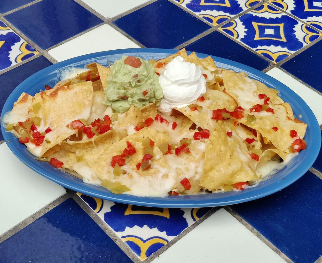 Nachos el Deluxe · Melted cheese over refried beans, chips, mild red, and green chilies. Served with guacamole and sour cream. Vegetarian.