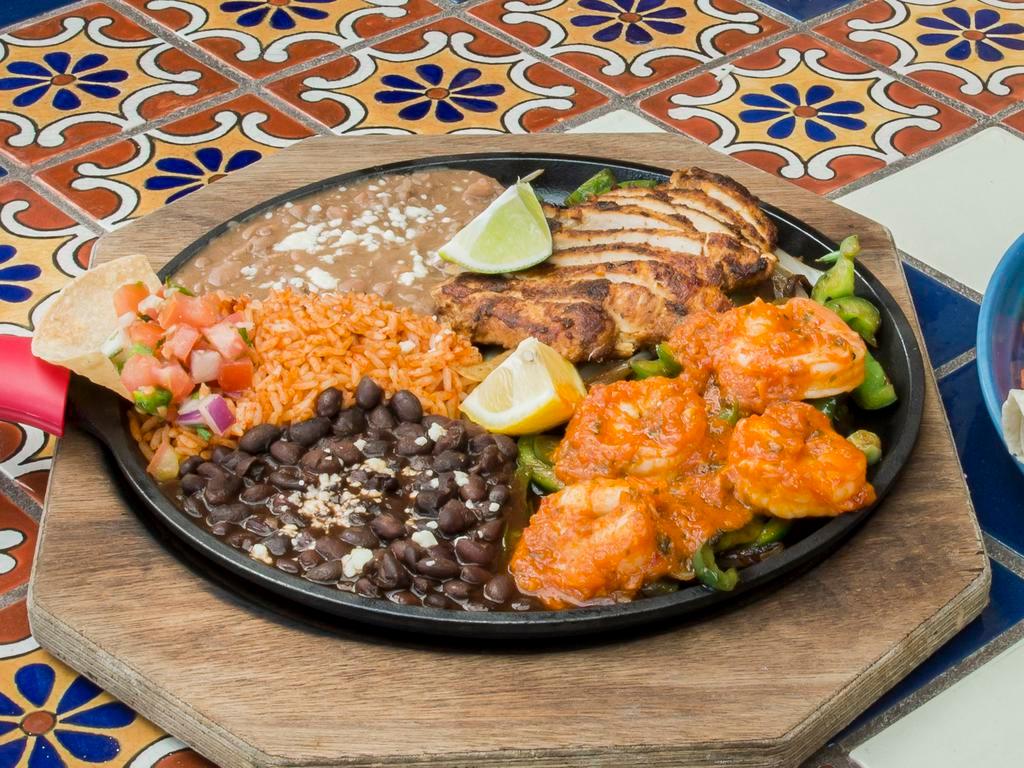 Chicken and Shrimp Combo · You'll hear it coming. Served on a sizzling platter, accompanied with our specially spiced, sautéed onions and peppers. All fajitas are served with our famous Mexican rice and beans, sour cream, guacamole, lettuce, tomatoes, cheese, and warm flour/corn tortillas.