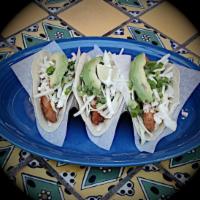 Fish Tacos del Mar · 3 pieces. Baja-style, beer-battered fish, scallions, orange slaw, three-pepper sauce, and av...