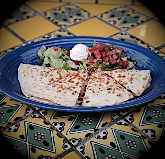 Quesadilla Extravaganza · Seasoned chicken, ground beef, pork carnitas or sauteed spinach in a flour tortilla baked with salsa fresca, mild chiles, and cheese. Served with guacamole, sour cream, and salsa fresca. Vegetarian.