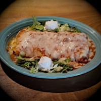 Burrito Supreme · Shredded chicken, seasoned ground beef or pork carnitas with refried beans baked in red chil...
