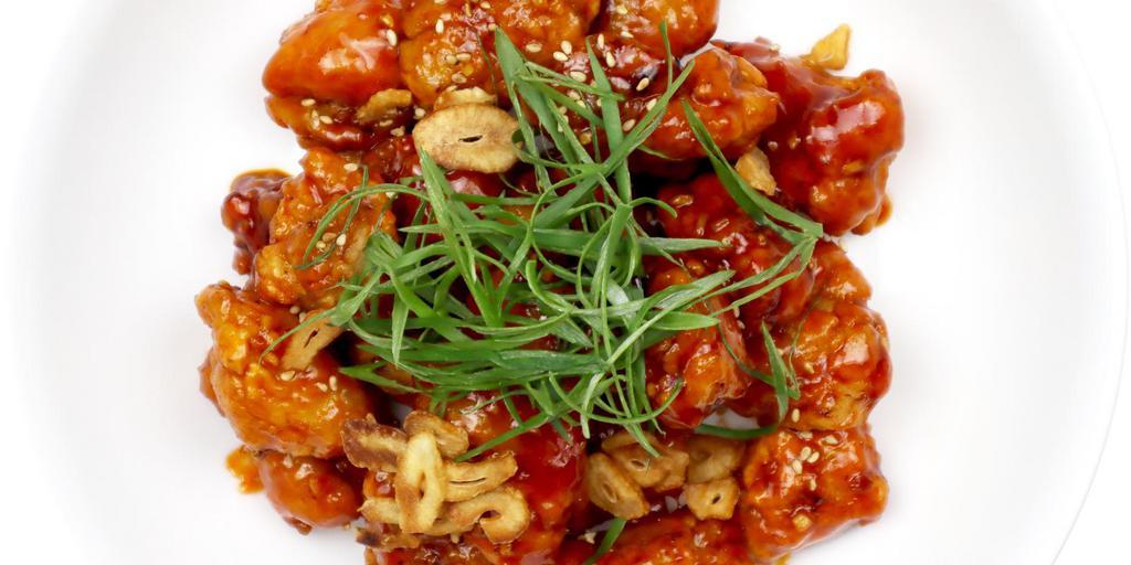 Korean Fried Chicken · Sweet and spicy boneless fried chicken packed with infused flavors topped with fried garlic chips and scallions.