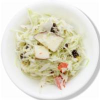 Korean Cole Slaw · Shredded cabbage mixed in our house sauce with carrots, corn, peas, and raisins.