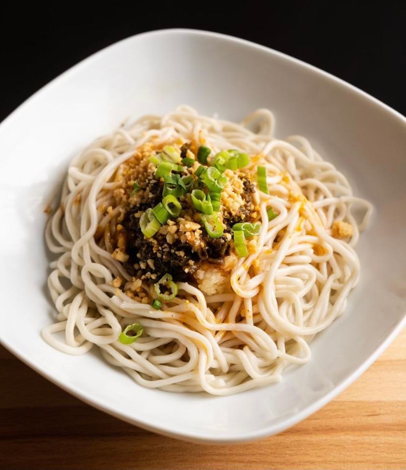 Dan Dan noodles · Spicy, Szechuan classic dish with spicy minced ground pork mixed with house special hot oil, peanuts and sauce topped over steamed noodles.