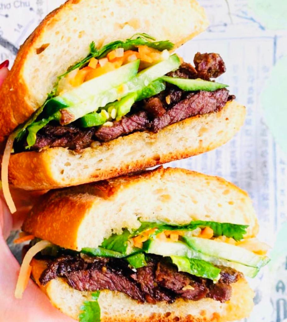 Caramelized Beef Baguette Sandwich · Grass-fed beef. Pickled daikon, carrot, cucumber, jalapeno and cilantro on a French baguette. Served with taro chips. 