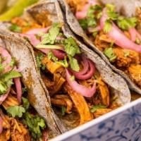 Cochinita Pibil Taco · Oven-roasted pork served with red pickled onion.