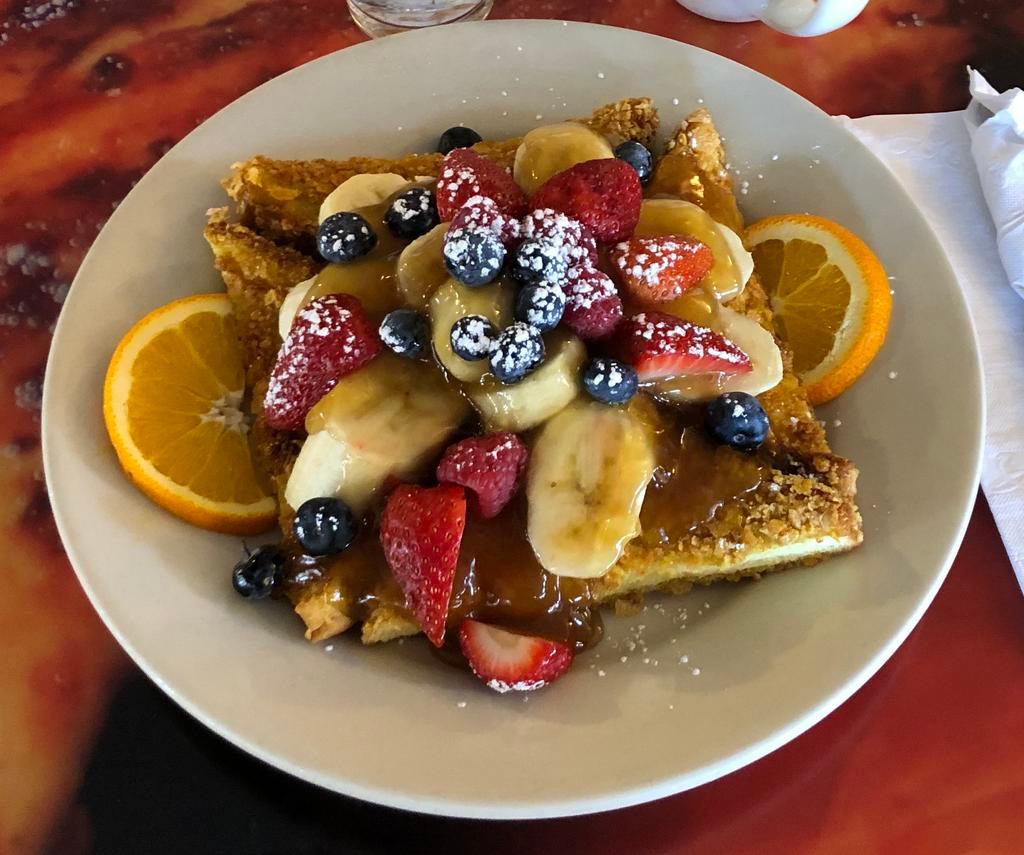 Crunchy French Toast · Dipped in our crunchy batter and grilled golden brown, served with caramelized bananas and fresh berries.