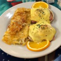 Classic Eggs Benedict · Poached eggs atop ham on toasted English muffin with savory hollandaise sauce and hash browns.
