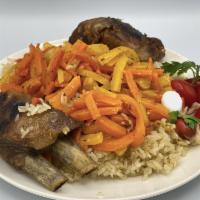 Beef Plov · Rice pilaf cooked in a kazan with chunks of beef, carrots, and chickpeas, topped with scalli...