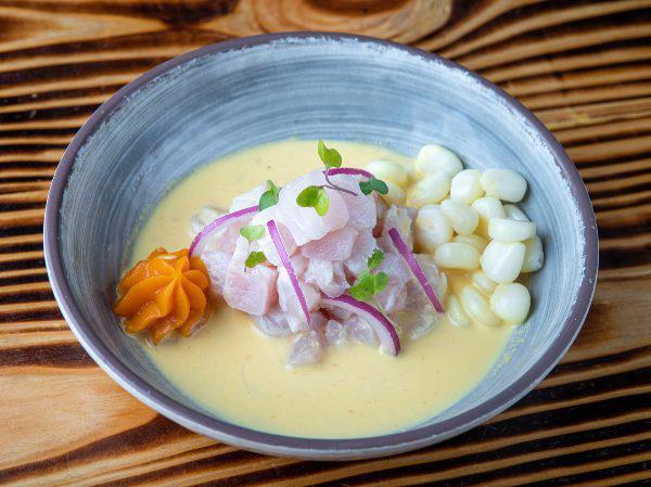 Ají Amarillo Ceviche · Peruvian yellow pepper. Marinated lightly in lime juice and seasoned with Peruvian limo chili, fresh cilantro, and onion, garnished with sweet potato, and choclo (Peruvian giant corn).