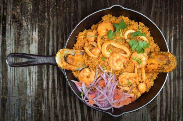 Arroz con Mariscos · Our best seafood combination of shrimp, squid and scallops, all mixed with rice, red pepper, cilantro and Peruvian.