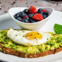 **Avocado Toast · House made avocado spread lathered on toasted nine grain, topped with one sunny up egg, spri...