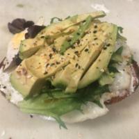 Avocado Toast · Fresh sliced avocado, fried egg, herbaceous cream cheese and spring mix on a sliced sour slab 