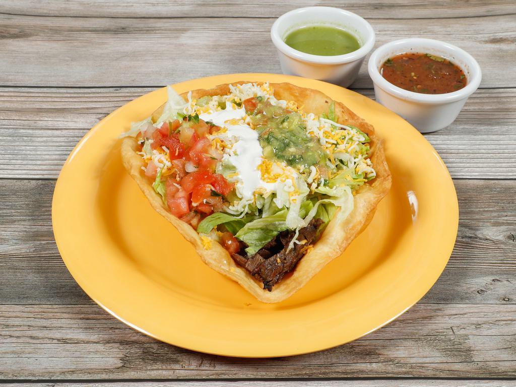 Taco Salad · Large crispy flour tortilla shell filled with whole pinto beans, your choice of meat, lettuce, cheese, salsa fresca, guacamole and sour cream.