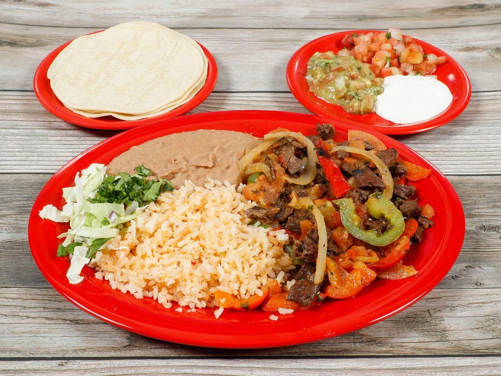FAJITAS · Skirt steak, red and green bell peppers and onions in a cilantro garlic butter sauce with salsa fresca and salsa ranchera. Served with guacamole, sour cream, salsa fresca, rice, beans and your choice of tortillas.