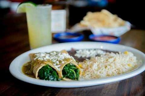 Spinach Enchiladas · Two enchiladas filled with spinach and cheese top with tomatillo sauce and fresco cheese, white rice and refried black beans.