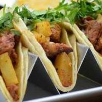 Tacos Al Pastor · Marinated pork topped with onions, pineapple, and cilantro. Served with rice and beans