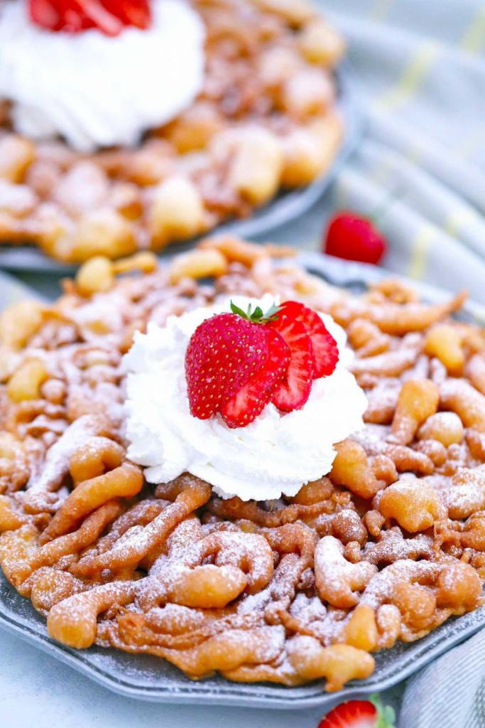 Strawberry Funnel Cake · Funnel Cake topped with Fresh Chopped Strawberries, Strawberry Glaze, and Whipped Cream 