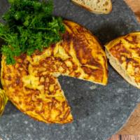Tortilla Espanola · Traditional Spanish omelet with potatoes served with mojo picon.
